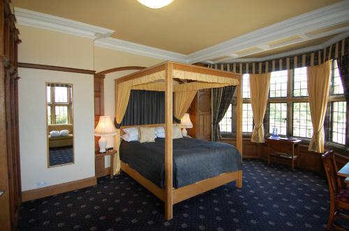惠特比邓斯利庄园乡村别墅酒店的一间卧室,卧室内配有一张天蓬床