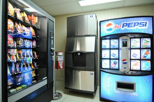 拉法叶Baymont by Wyndham Lafayette - Purdue University的冰箱旁的商店里的汽水机