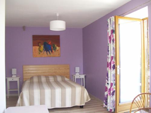 NoirpaluLes Rhodos的一间卧室设有紫色的墙壁、一张床和镜子