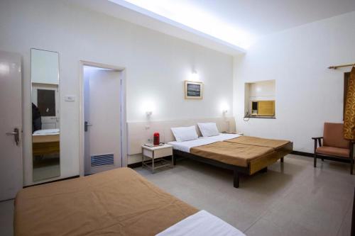 阿格拉Hotel Ranjeet的酒店客房,配有两张床和椅子