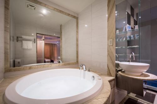 三峡青青花园汽车旅馆的一间带大浴缸和水槽的浴室