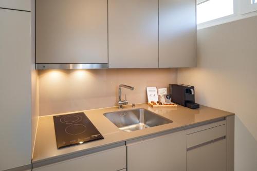 格拉特布鲁格achesa homes的厨房配有水槽和白色橱柜