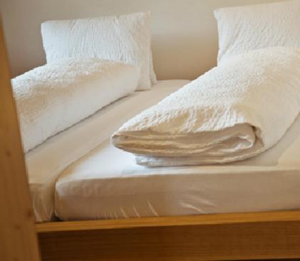 布赖尔阿尔品纳公寓的一张带白色床单和枕头的床