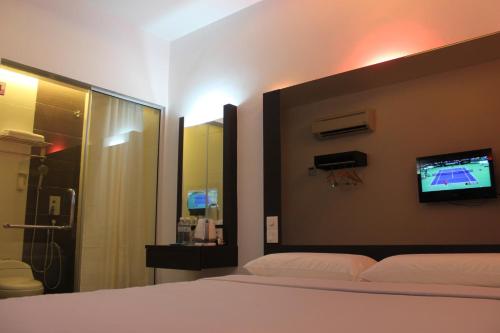 巴生梦幻酒店的卧室配有一张床,墙上配有电视。