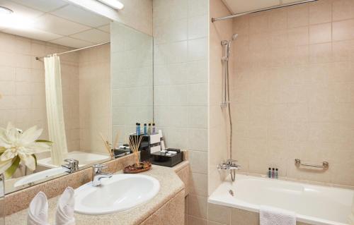 迪拜迪拜兹切公寓式酒店的一间带水槽、浴缸和镜子的浴室