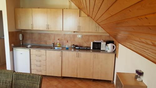 比克Apartman Nóra II.的厨房配有木制橱柜和台面