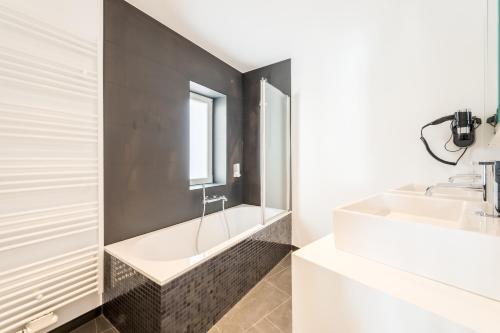 布鲁塞尔Smartflats - Toison d'Or的浴室配有白色浴缸和水槽