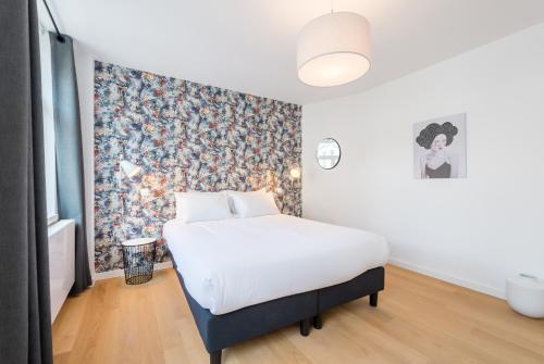布鲁塞尔Smartflats - Toison d'Or的一间卧室配有一张带花卉壁纸的床