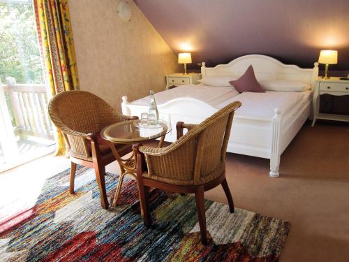 拉尔斯维克Hotel Klaus Störtebeker的卧室配有一张床和一张桌子及椅子