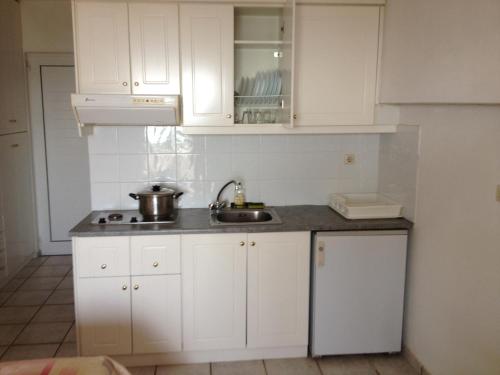 马尔马里吉卡斯公寓式酒店的厨房配有白色橱柜和水槽