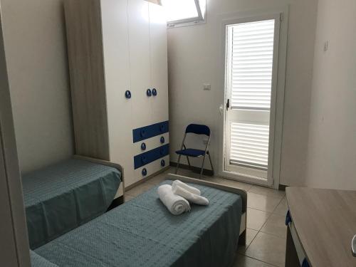 托雷拉皮罗Casa Gada的一间设有两张床和一张蓝色椅子的房间