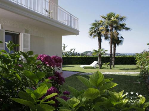 乌尔比诺Residenza Ambrogi的一个带椅子和棕榈树的庭院的房子