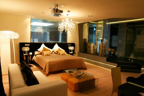 Cadrete卡得利特酒店的一间卧室配有一张床、一张沙发和一个吊灯。