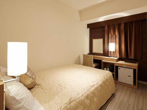 UNIZO INN新大阪旅馆客房内的一张或多张床位