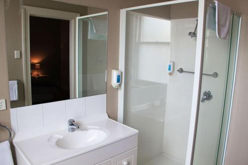 朗塞斯顿运动员酒店的白色的浴室设有水槽和淋浴。