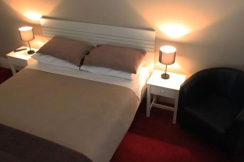 朗塞斯顿运动员酒店的一间卧室配有一张白色床和两盏灯。