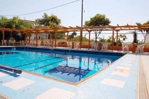 圣帕拉斯凯维Hotel Aphroditi的一个带椅子和凉亭的大型游泳池