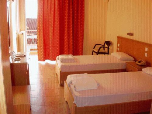 圣帕拉斯凯维Hotel Aphroditi的酒店客房设有三张床和窗户。