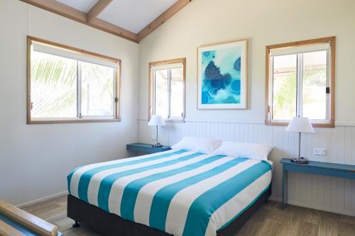 麦夸里港NRMA港麦格理布里克沃假日公园的一间卧室设有一张床和两个窗户。