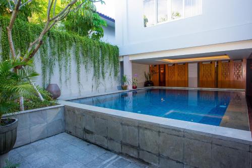 沙努尔马哈拉卡斯米精品酒店的房屋中间的游泳池