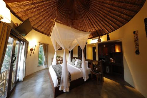 克拉玛斯马拉河野外巴厘旅馆的一间卧室配有一张带天蓬的床