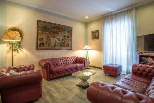 罗马博物馆酒店的客厅配有真皮沙发和桌子