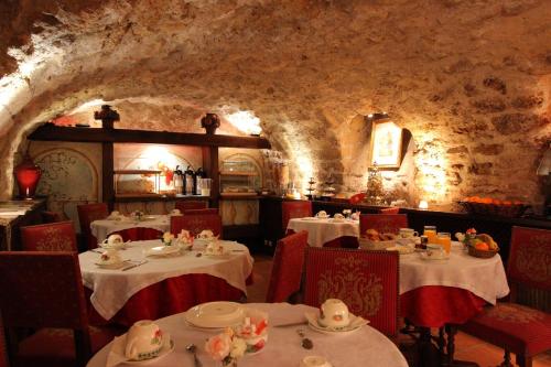 巴黎布雷多内里酒店的一间带桌椅和石墙的餐厅