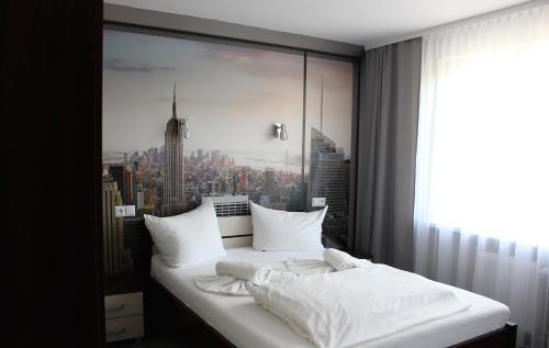 科沙林Hotel City的一张位于带大窗户的房间内的床铺
