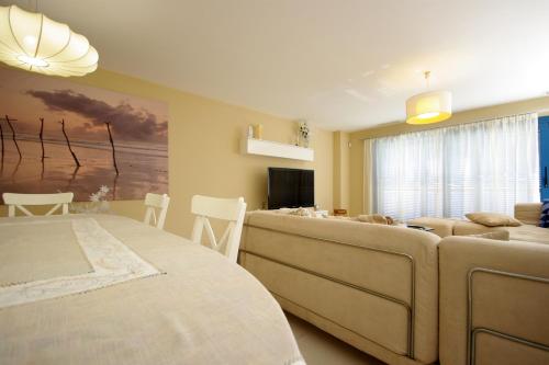 塔里法Livingtarifa Apartamento La Isla的一间卧室配有一张床,客厅配有沙发