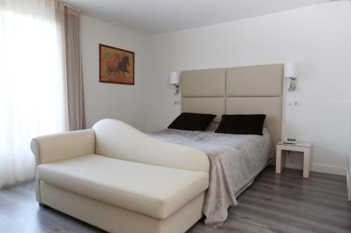 布朗屈埃福尔Les Criquets Hôtel & Spa的白色卧室配有床和白色沙发