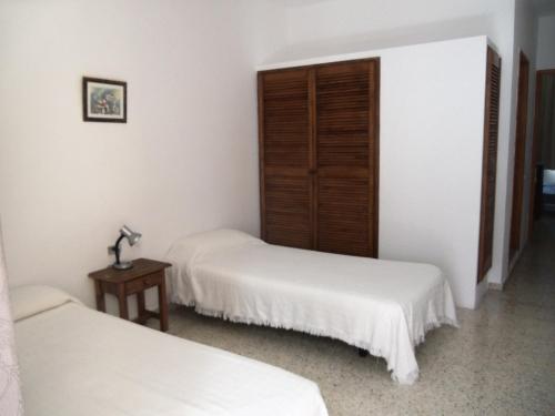 塔扎克蒂伊萨公寓酒店的配有2张床的白色墙壁和桌子