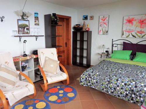 伊科德洛斯维诺斯El Lagar的一间卧室配有一张床和两把椅子