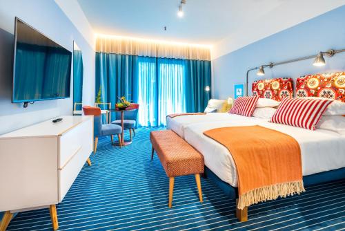 丰沙尔Pestana Casino Studios的酒店客房设有两张床和电视。