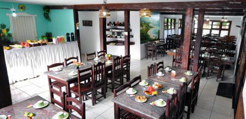 塞古罗港绿谷酒店的一间餐厅配有桌椅,提供食物