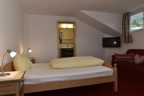 菲施巴豪贝格姆勒阿尔特酒店的一间带床和沙发的小卧室