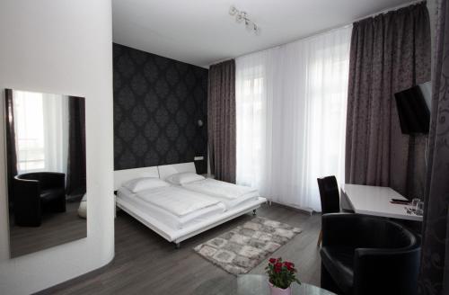 威斯巴登路易森霍夫酒店的客厅配有白色的床和书桌