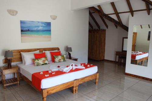 Anse a La Mouche格兰卡兹旅馆的一间卧室配有一张带红白毯子的床