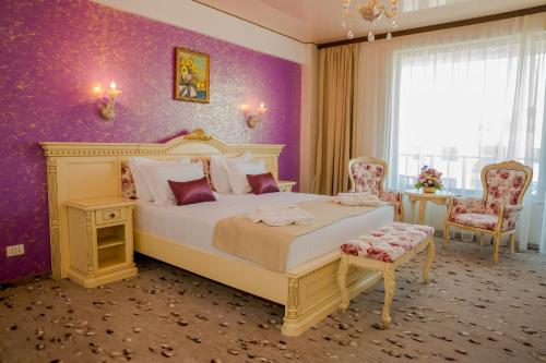 北马马亚-讷沃达里Almar Luxury的一间卧室设有一张大床和紫色的墙壁