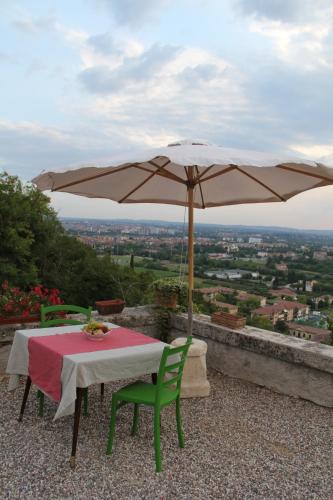 维罗纳Relais Villa Ambrosetti的屋顶伞下的桌椅