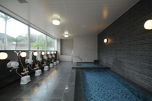 西之表市莱克斯通种子岛酒店的大楼内带游泳池的大型浴室