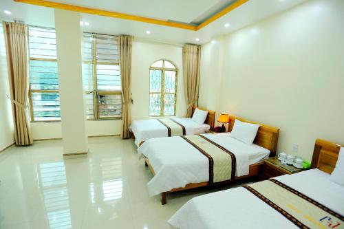 河江惠阳酒店的酒店客房,设有三张床和两扇窗户