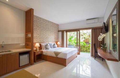 乌布乌布格兰德赛哈提及Spa酒店的一间卧室配有一张床、一个水槽和一台电视