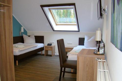 奥斯纳布吕克胡克斯米勒餐厅及酒店的客房设有两张床、一张桌子和一个窗户。