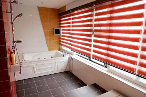 釜山V Motel Songdo的带浴缸的浴室和窗户
