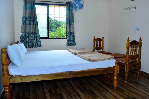 MāvingundiHills View Stay的一间卧室配有一张带两把椅子的床和一扇窗户