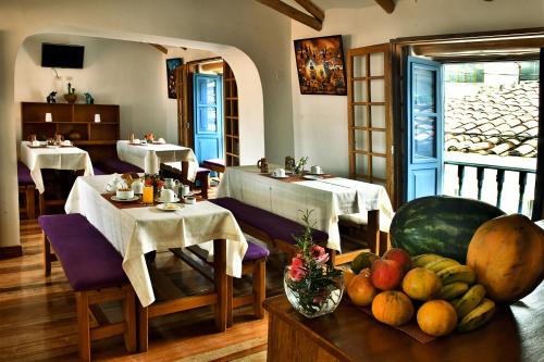 库斯科Amaru Colonial的餐厅设有两张桌子和一碗水果