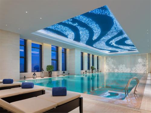 抚顺抚顺万达嘉华酒店的一座拥有蓝色天花板的大型游泳池