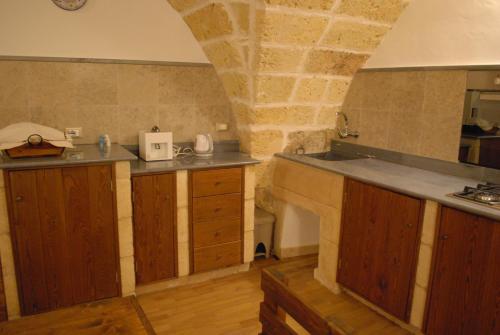 乌真托El Tablao的厨房配有木制橱柜和石墙