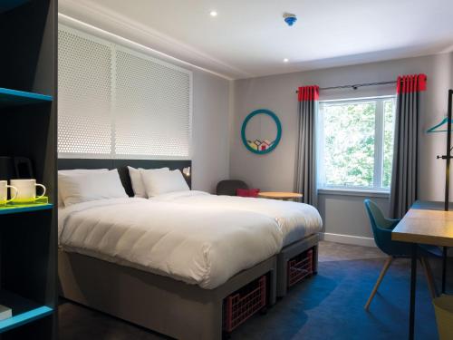 费勒姆索伦特酒店的一间卧室配有一张床、一张书桌和一个窗户。