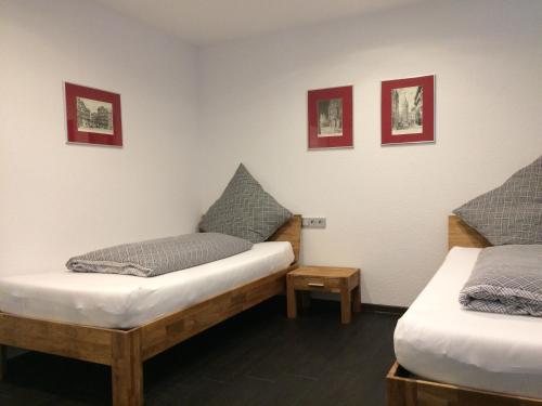 MorschenFeWo Bettenhausen的一间设有两张床的客房,墙上挂有图片